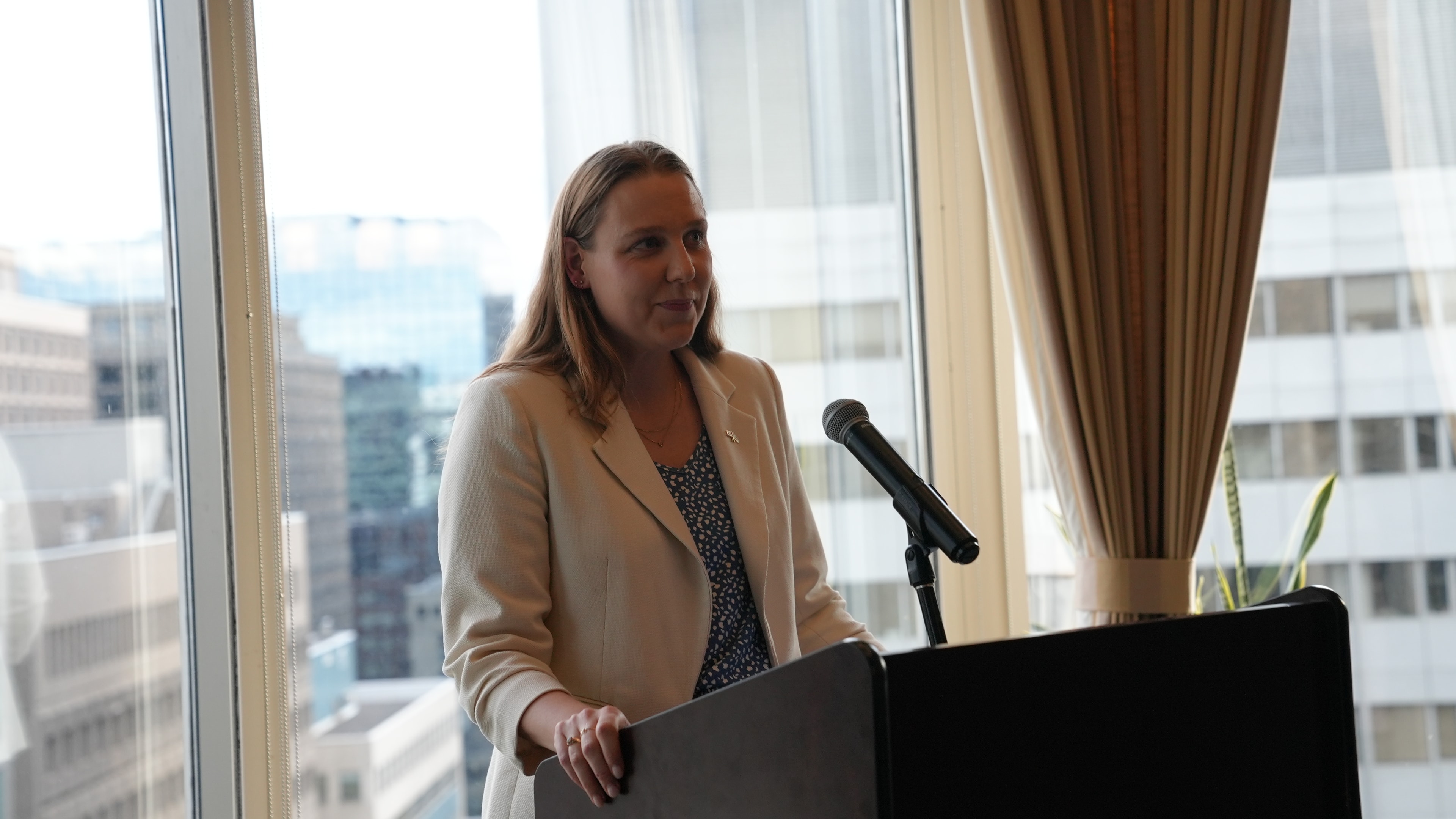 Claire speaking at a podium